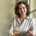 Rebecca Lazzelle, author, retreat host and energy healing practitioner, smiling with arms crossed