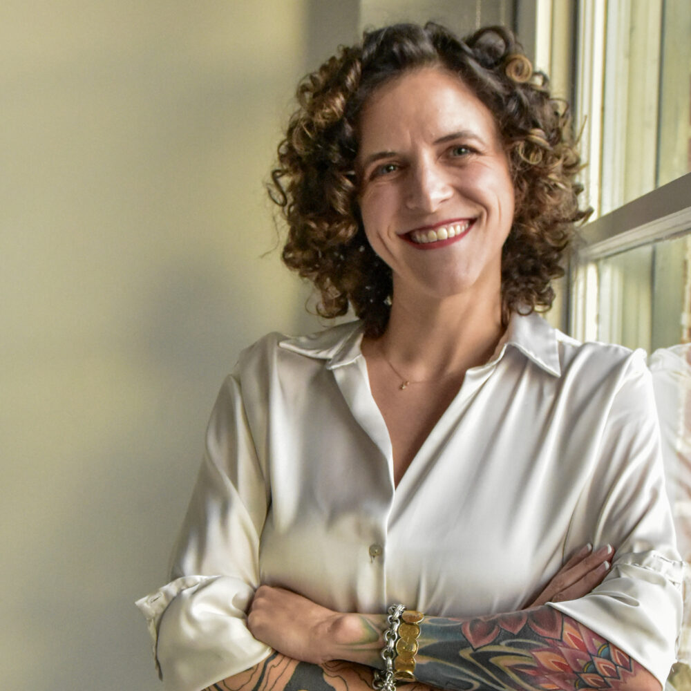Rebecca Lazzelle, author, retreat host and energy healing practitioner, smiling with arms crossed